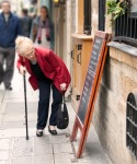 Old woman checks the lunch menu.